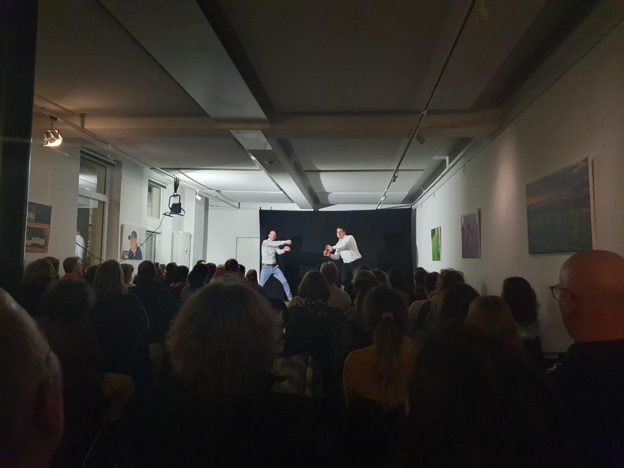 Publikum blickt von hinten auf die Bühne bei der ImproComedy „Zwischen den Zeilen“ mit Lux am 06.03.2026 in Freiburg